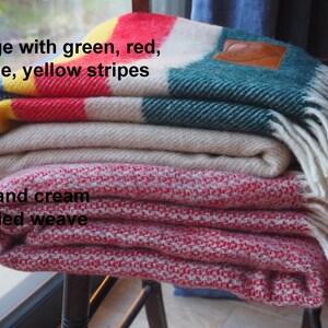 beige throw with green, yellow, red and blue throw and mottled red and cream throw