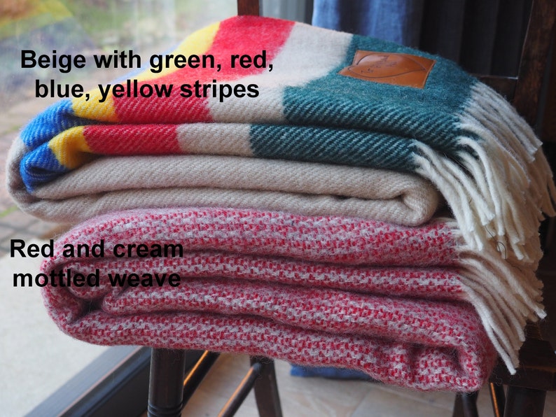 beige throw with green, yellow, red and blue throw and mottled red and cream throw