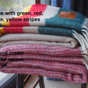 beige throw with green, yellow, red and blue throw and mottled red and cream throw