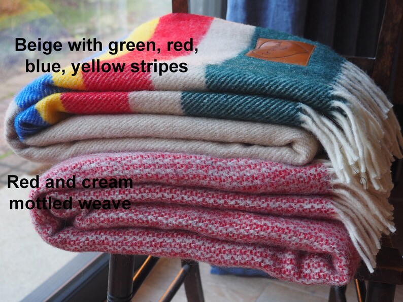 beige throw with green, yellow, red and blue throw and mottled red and cream throw