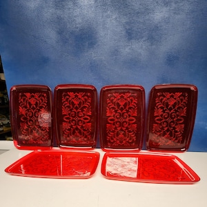 May include: Set of five red plastic serving trays with an embossed floral design.