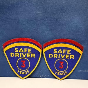 May include: Two embroidered patches with a blue background, featuring the text "SAFE DRIVER" and "3 YEARS". The patches have a yellow and red border.