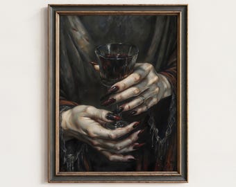 May include: Framed artwork depicting hands holding a glass of red liquid. The hands have long, dark red fingernails and rings. The artwork has a gothic or vintage aesthetic, with a dark colour palette.