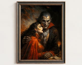 May include: A framed wall art print depicting a dark-haired figure in a vibrant orange dress being embraced by a pale, sharp-featured individual in a black coat with a red collar. A single lit candle sits on a table beside them against a dark background.