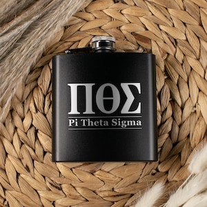 May include: A black stainless steel flask with a silver cap. The flask features the Greek letters ΠΘΣ and the words "Pi Theta Sigma" in a white, sans-serif font. The flask is set against a woven background.