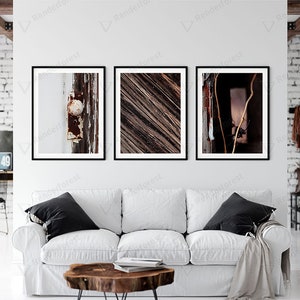 May include: Three framed photographs of abstract textures. The first photo shows a close-up of a weathered wooden door with a rusty metal knob. The second photo shows a close-up of a wooden surface with a striped pattern. The third photo shows a close-up of a wooden surface with a branch and a window in the background.