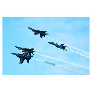 May include: Four blue and yellow fighter jets fly in formation, leaving white smoke trails against a clear blue sky.