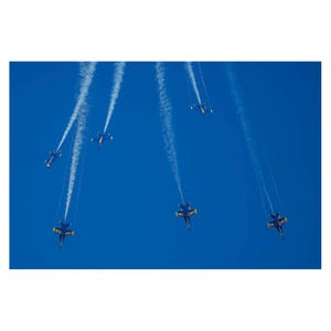 May include: Six blue and yellow airplanes fly in formation, leaving white smoke trails against a bright blue sky.