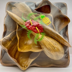May include: A set of four wooden bowls and two wooden serving spoons in a clear plastic bag. The bowls are in the shape of a flower and are nested inside each other. The spoons are long and thin. The bag has a sticker that says "Aloha from Hawaii".