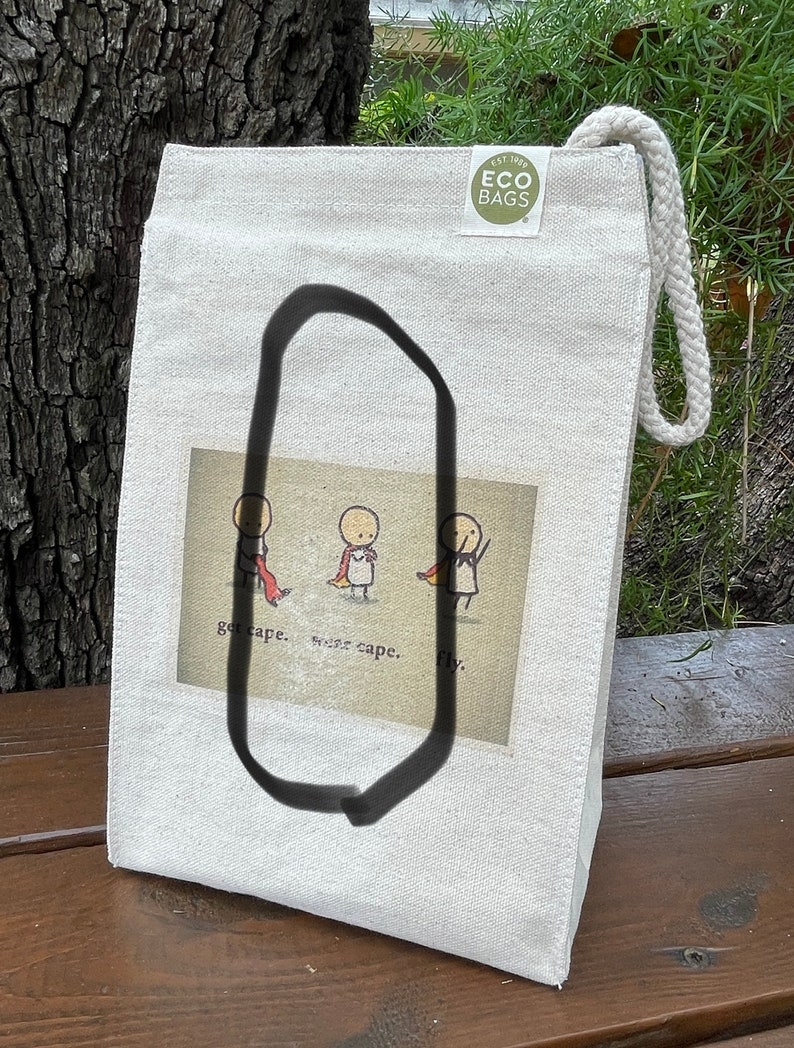 May include: A white canvas tote bag with a brown and white illustration of three stick figures wearing capes. The text "get cape. wear cape. fly." is printed below the illustration. The bag has a green logo that says "EST. 1992 ECO BAGS".