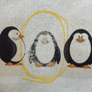May include: Three black and white penguins with yellow beaks and feet are arranged in a circle on a beige canvas background. A yellow circle surrounds the penguins.