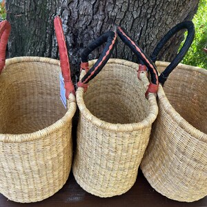 Puede incluir: Tres cestas cil&iacute;ndricas altas tejidas con fibras naturales de color tostado claro. Cada cesta cuenta con un asa resistente unida al borde. Una cesta tiene un asa de color marr&oacute;n rojizo, mientras que las otras dos tienen asas negras.