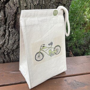 May include: A white canvas lunch bag with a green bicycle design and the text "ECO BAGS" on a green circle.