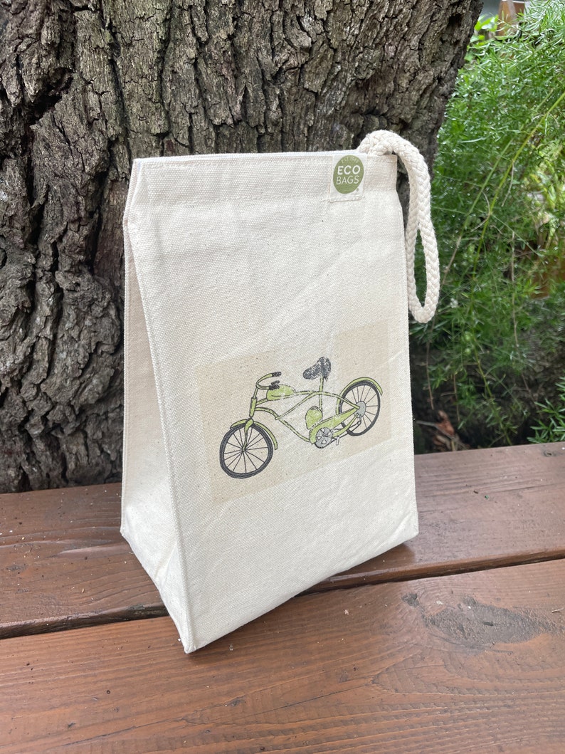 May include: A white canvas lunch bag with a green bicycle design and the text "ECO BAGS" on a green circle.