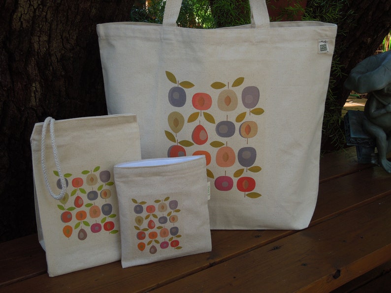 Puede incluir: Tres bolsas de lona con un patr&oacute;n geom&eacute;trico de c&iacute;rculos y hojas de colores. La bolsa m&aacute;s grande tiene un fondo blanco y las bolsas m&aacute;s peque&ntilde;as tienen un fondo crema.