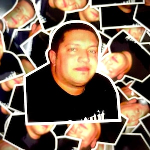 May include: A collage of images featuring a man's face. The images are arranged in a random pattern, creating a unique and abstract design.