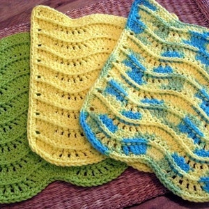 May include: Three crocheted dishcloths in green, yellow, and blue with a wavy pattern.