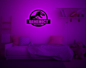 May include: A purple bedroom with a bed, a dinosaur silhouette with the name "BENEDICT" underneath, and a shelf with books and a stuffed animal.