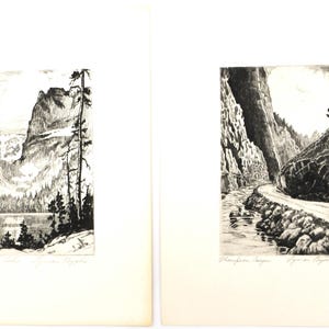 May include: Two black and white landscape prints. The first print shows a mountain lake with a mountain range in the background. The second print shows a winding road through a canyon.