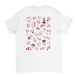 Könnte beinhalten: Weißes T-Shirt mit einem roten japanischen Design. Die Illustrationen umfassen eine Pagode, Kirschblüten, eine Glückskatze und andere kulturelle Symbole. Das T-Shirt besteht aus einem weichen, bequemen Material.