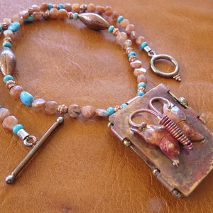 Beautiful burnished copper plated locket with butterfly design and Sunstone beads