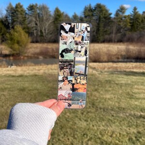 Pu&ograve; includere: Un segnalibro di plastica trasparente con un collage di foto. Le foto mostrano una coppia in diverse localit&agrave;, tra cui un lago, una ruota panoramica e una strada cittadina. Il testo "Fine Offer" &egrave; stampato sul segnalibro.