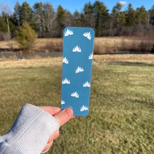 Pu&ograve; includere: Un segnalibro blu con un motivo a castello bianco. Il segnalibro &egrave; realizzato in un materiale resistente ed &egrave; perfetto per segnare il tuo posto in un libro.