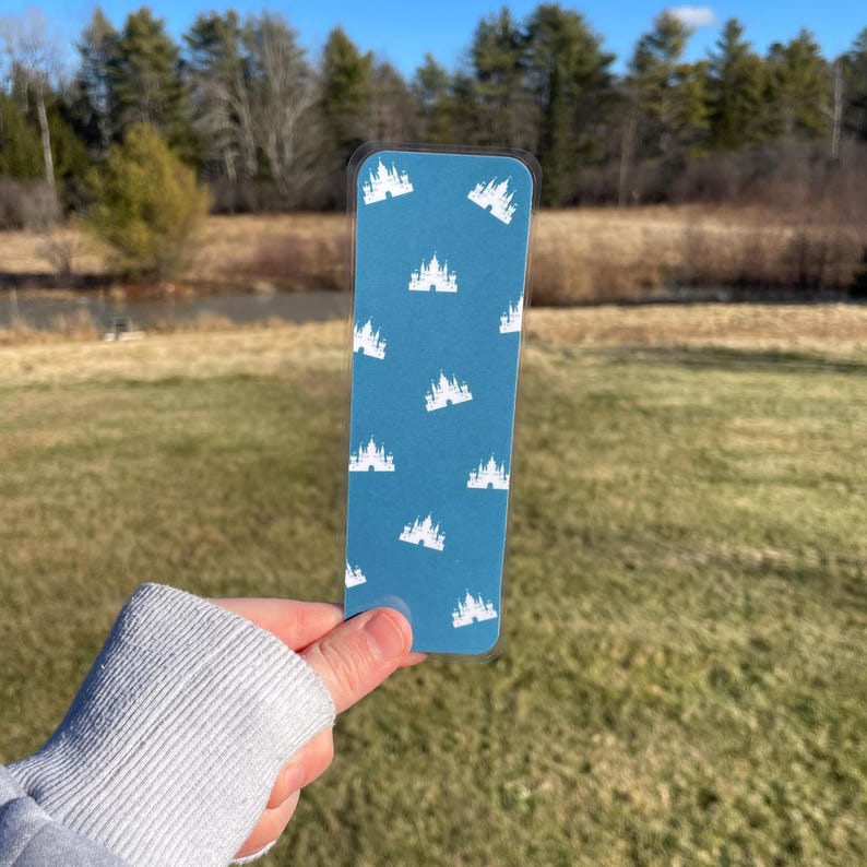 Pu&ograve; includere: Un segnalibro blu con un motivo a castello bianco. Il segnalibro &egrave; realizzato in un materiale resistente ed &egrave; perfetto per segnare il tuo posto in un libro.