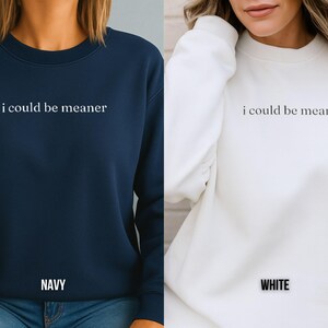 May include: Navy blue and white sweatshirts with the phrase "i could be meaner" printed in white. The navy sweatshirt has "NAVY" printed at the bottom. The white sweatshirt has "WHITE" printed at the bottom.
