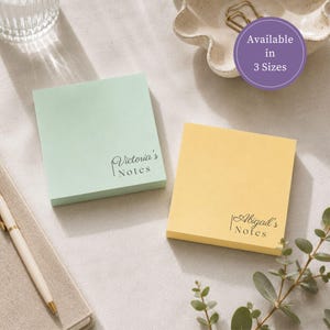 以下が含まれることがあります： パステルミントグリーンとソフトイエローの正方形の付箋パッド2つ。ミント色のパッドには「Victoria's Notes」、黄色のパッドには「Abigail's Notes」というテキストが印刷されています。紫色の円形バッジには「Available in 3 Sizes」と記載されています。