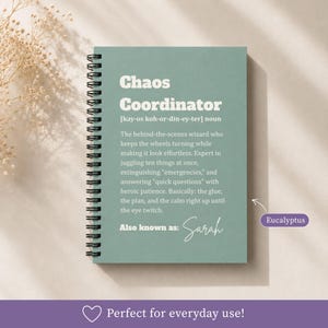 May include: A spiral-bound notebook with a sage green cover featuring white text that defines the term Chaos Coordinator. The text includes a phonetic pronunciation, a humorous definition, and the phrase Also known as: Sarah in script font.