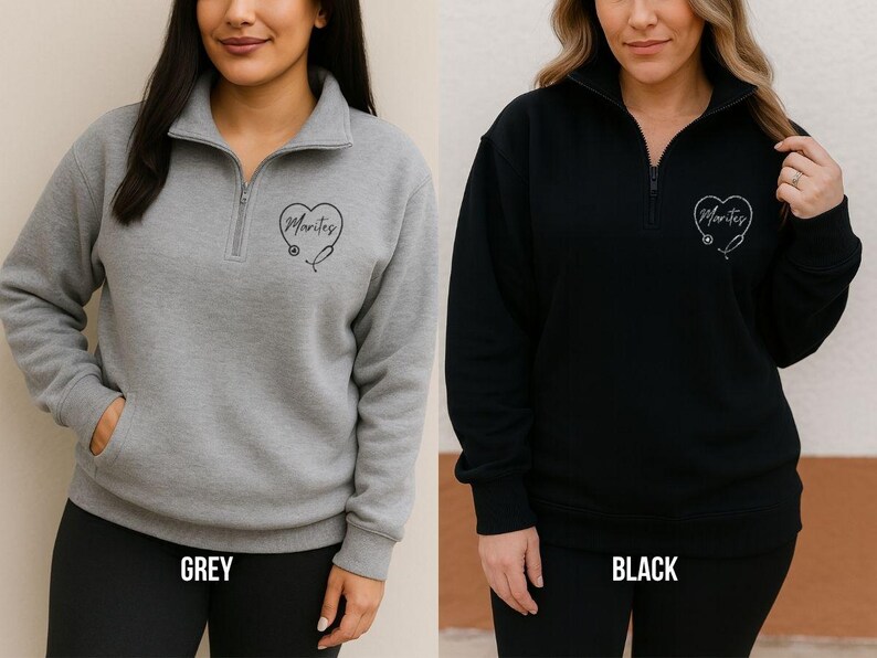 May include: Grey and black quarter-zip sweatshirts. Each sweatshirt has a heart-shaped design with the word "Marites" and a stethoscope. The grey sweatshirt has a front pocket. The word "GREY" is printed at the bottom of the grey sweatshirt. The word "BLACK" is printed at the bottom of the black sweatshirt.