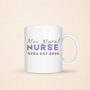 Puede incluir: Una taza de cer&aacute;mica blanca con el texto en cursiva negra Neo-Natal, el texto en bloque morado NURSE y el texto negro NINA EST.2026. La taza tiene un cuerpo cil&iacute;ndrico est&aacute;ndar con un asa curva en el lado derecho para sostener el recipiente.