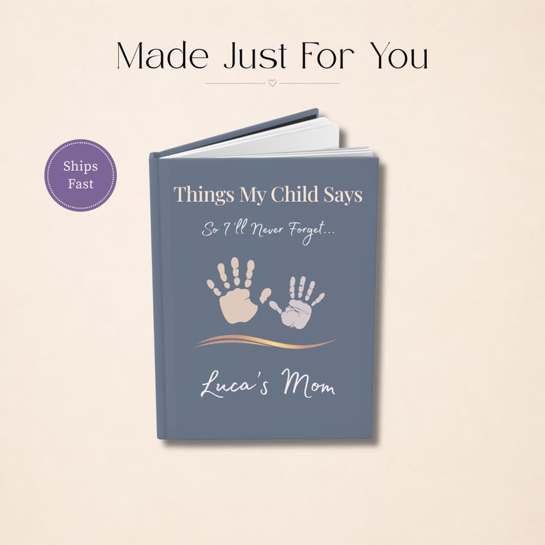 May include: A blue hardback journal with the text Things My Child Says So I'll Never Forget and Luca's Mom printed on the front cover. The cover features two light-coloured handprint illustrations and a gold-toned wavy line graphic element.