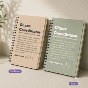 May include: Two spiral-bound notebooks with sandstone and sage covers. Each features the text Chaos Coordinator, a phonetic pronunciation, a definition of the term, and the phrase Also known as followed by a handwritten name, Ema or Joey.