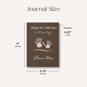 May include: A brown journal titled Things My Child Says So I'll Never Forget... with two handprints and the text Eliana's Mom. Dimensions are 20.5 cm by 14.6 cm with a thickness of 1.4 cm, as indicated by the measurement labels.
