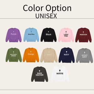 May include: A selection of unisex sweatshirts in various colors, including purple, baby blue, black, light pink, maroon, military green, orange, sand, navy, sport grey, dark heather, and white. Each sweatshirt has a small graphic and the color name printed on it.