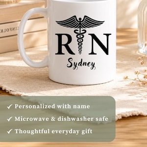 May include: A white ceramic mug featuring a black caduceus symbol between the letters R and N, with a personalized name printed below in a script font. The design is displayed on multiple mugs with names including Melissa, Sydney, Sara, and Jenna.