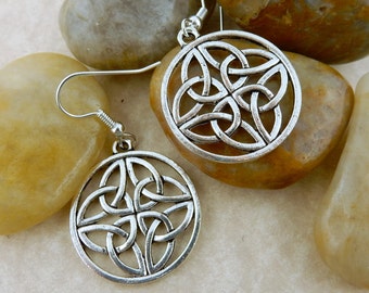 May include: A pair of silver Celtic knot earrings. The earrings are round and feature a detailed knot design.