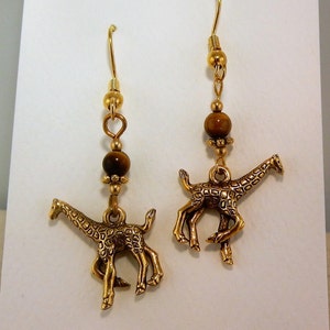 May include: Gold tone earrings with tiger's eye beads and giraffe charms.