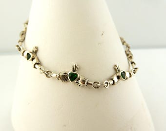 May include: A silver bracelet with a Celtic knot design and green heart charms.