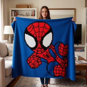 May include: A blue blanket with a pixelated Spider-Man design. The superhero is depicted in red, black, and white against a blue backdrop. The blanket is held up, displaying the full image of the character.