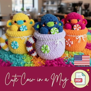 May include: Three colorful crochet cow plushies in mugs. The cows are yellow, blue, and pink, each with a different colored muzzle and ears. The mugs are yellow, lavender, and orange, with white bows and candy accents. The text "Cute Cow in a Mug" is at the bottom.