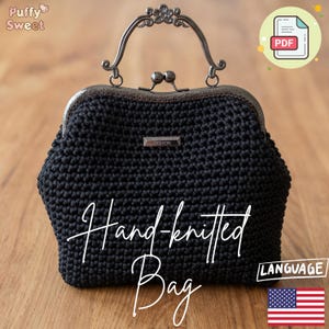 May include: A black hand-knitted bag with a decorative metal clasp and handle. The bag features the text "Hand-knitted Bag" in a script font. The bag has a "Fashion" label.