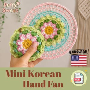 May include: A round, crocheted floral motif in shades of yellow, white, pink, and green, featuring a central yellow circle surrounded by white and pink petals, with a green scalloped border. It is held in front of a larger, pink crocheted circular frame.