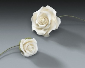 May include: Two white artificial roses with green stems and leaves are displayed against a gray background. One rose is fully bloomed, while the other is a smaller bud. The petals are detailed and textured.