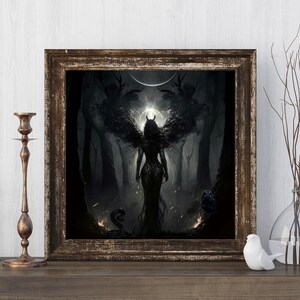 May include: A framed print of a dark fantasy illustration featuring a winged woman with horns standing in a forest. The woman is wearing a dark dress and has a glowing halo behind her. The forest is dark and mysterious, with trees and branches reaching up towards the sky. There is a snake and an owl in the foreground.