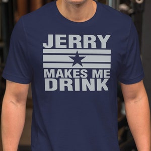 May include: A navy blue t-shirt with a white graphic that says "JERRY MAKES ME DRINK" with a white star in the middle of the text.