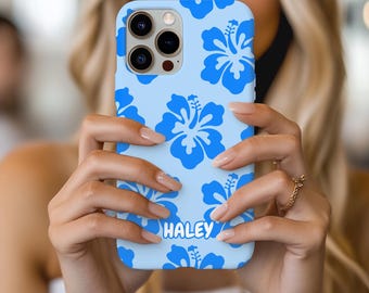 May include: A light blue phone case featuring a repeating pattern of blue hibiscus flowers. The name "HALEY" is printed in white script at the bottom. The case is held in front of a blurred background.