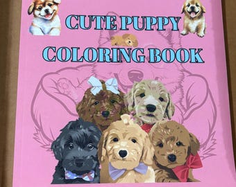 Peut inclure: Un livre de coloriage rose intitulé CUTE PUPPY COLORING BOOK en texte bleu. La couverture présente des illustrations de divers chiots, dont un avec un nœud blanc, un avec un nœud violet et un avec un nœud rouge, sur un fond rose.